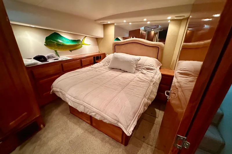 Dock Fee Yacht Photos Pics Luxurious bedroom in 1998 Viking 50 Convertible yacht with cozy bed and fish decor.