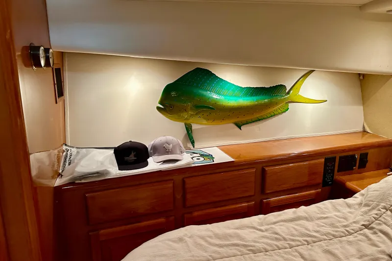 Dock Fee Yacht Photos Pics 1998 Viking 50 Convertible cabin with fish decor and hats on wooden dresser.