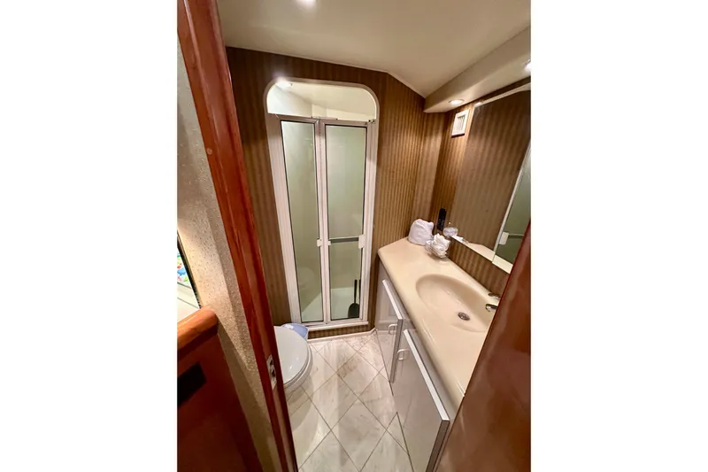 Dock Fee Yacht Photos Pics Bathroom interior of 1998 Viking 50 Convertible yacht, featuring shower and sink.
