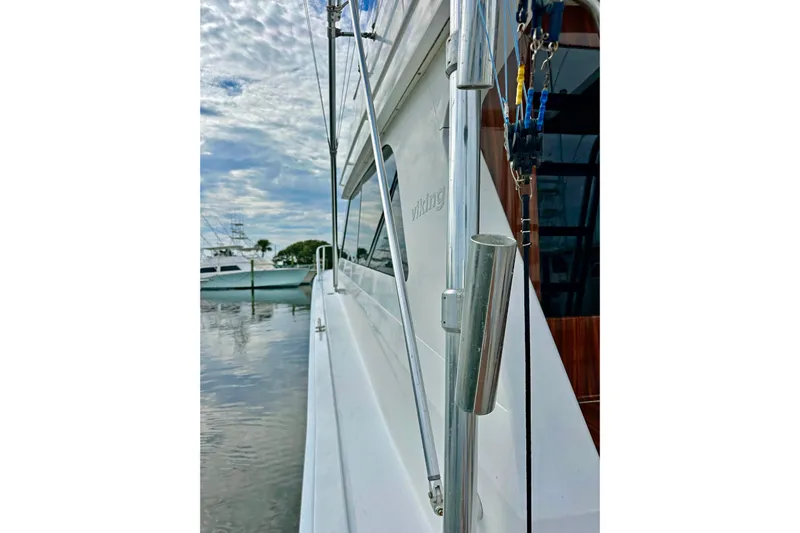 Dock Fee Yacht Photos Pics Side view of a 1998 Viking 50 Convertible yacht docked by the water.