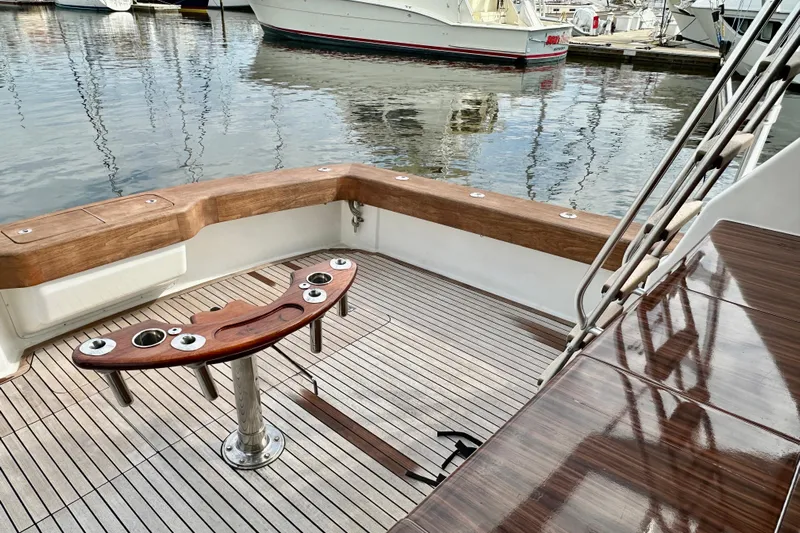 Dock Fee Yacht Photos Pics 1998 Viking 50 Convertible yacht deck with wooden seating and fishing rod holders.