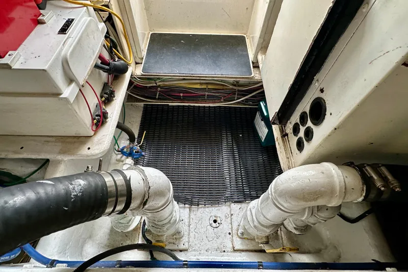 Dock Fee Yacht Photos Pics Engine room of a 1998 Viking 50 Convertible boat, showing pipes and wiring.