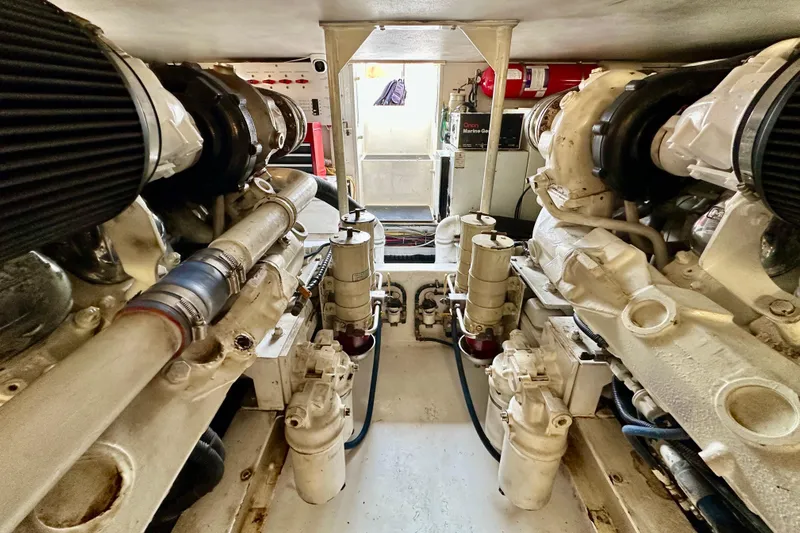 Dock Fee Yacht Photos Pics Engine room of a 1998 Viking 50 Convertible yacht, showcasing dual engines and mechanical components.