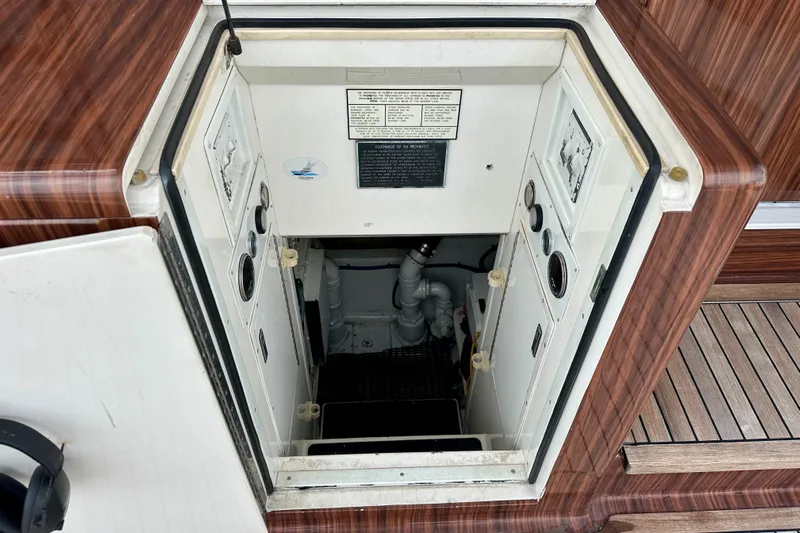 Dock Fee Yacht Photos Pics Engine room access on 1998 Viking 50 Convertible yacht, featuring wood paneling and control panels.