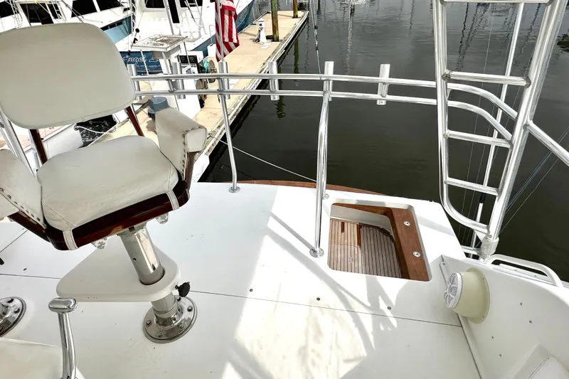 Dock Fee Yacht Photos Pics Captain's chair on 1998 Viking 50 Convertible yacht, overlooking marina with American flag.