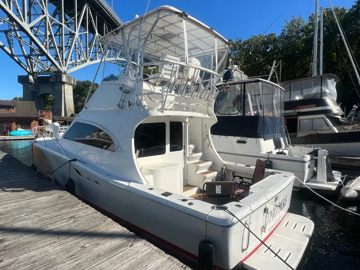 Uno Mas Yacht Photos Pics 2001 Luhrs 360 Convertible yacht docked under a bridge on a sunny day.