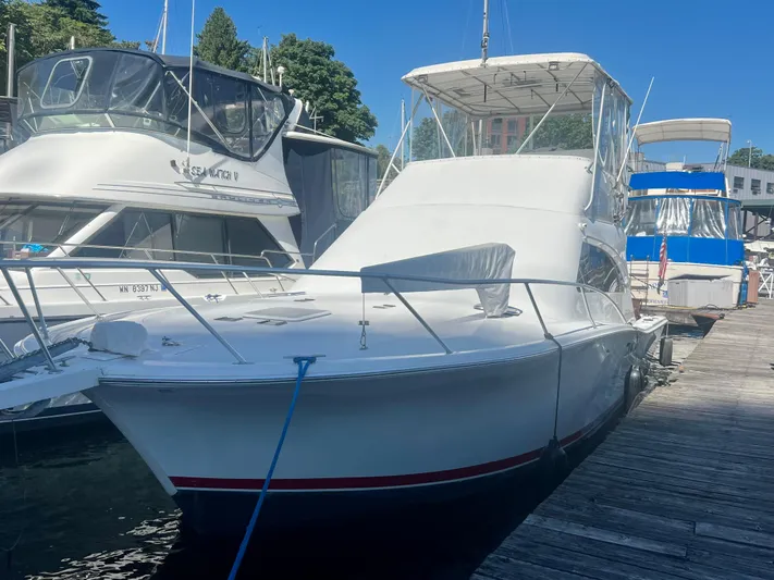 Uno Mas Yacht Photos Pics 2001 Luhrs 360 Convertible yacht docked at marina under clear blue sky.