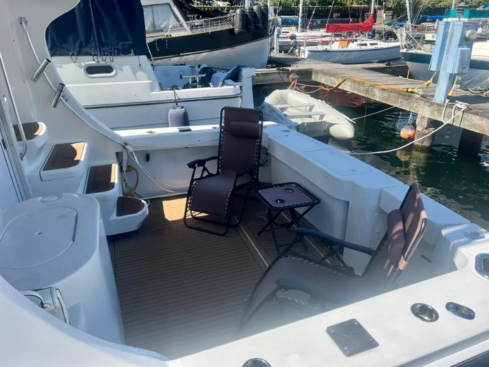 Uno Mas Yacht Photos Pics 2001 Luhrs 360 Convertible yacht deck with chairs and table, docked at marina.