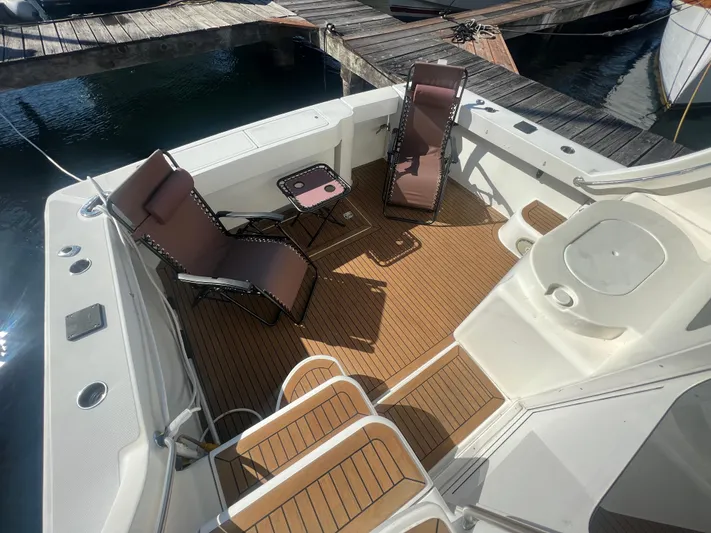 Uno Mas Yacht Photos Pics 2001 Luhrs 360 Convertible boat deck with chairs and table, docked at marina.