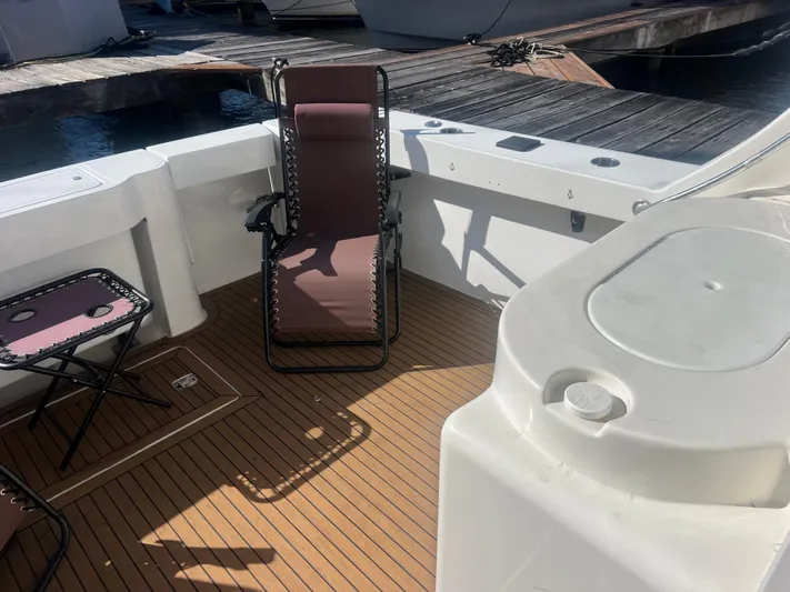 Uno Mas Yacht Photos Pics 2001 Luhrs 360 Convertible boat deck with chairs and wooden flooring.