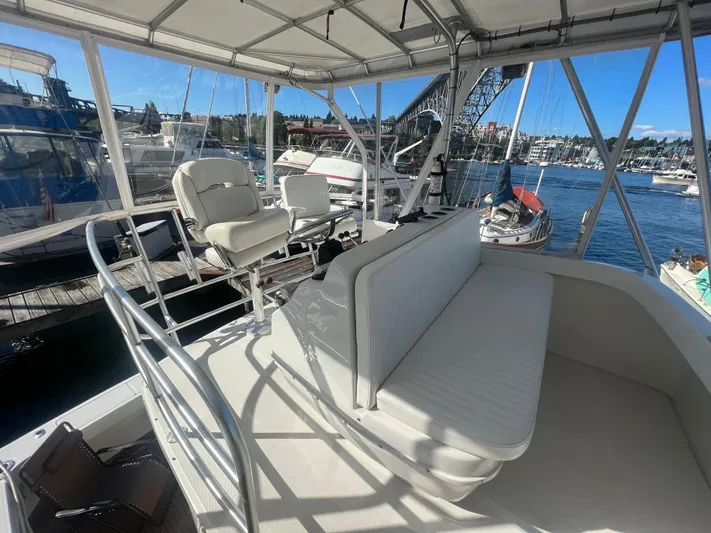 Uno Mas Yacht Photos Pics 2001 Luhrs 360 Convertible yacht interior with seating, docked in a marina under clear skies.