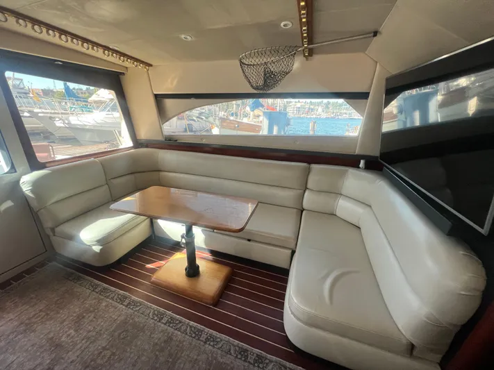 Uno Mas Yacht Photos Pics Luxurious interior of 2001 Luhrs 360 Convertible yacht with leather seating and wooden table.