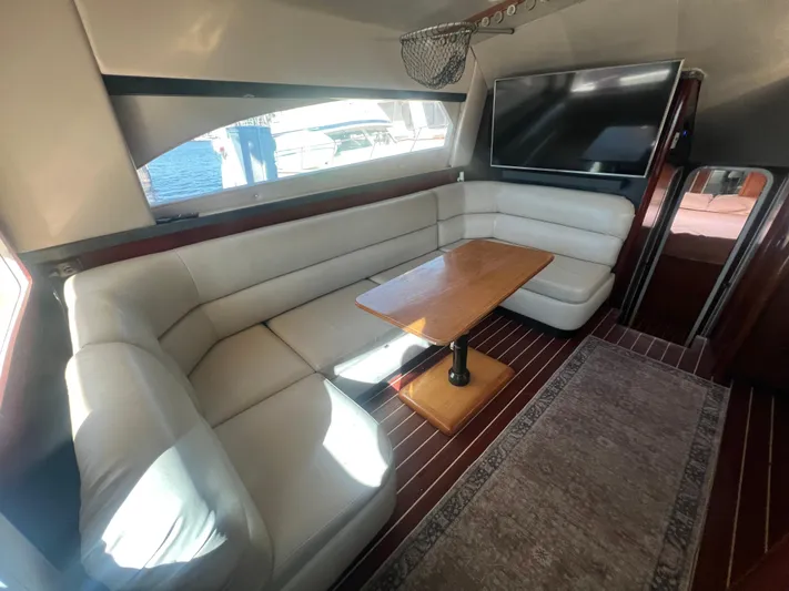 Uno Mas Yacht Photos Pics Luxurious interior of 2001 Luhrs 360 Convertible yacht with plush seating and wooden table.