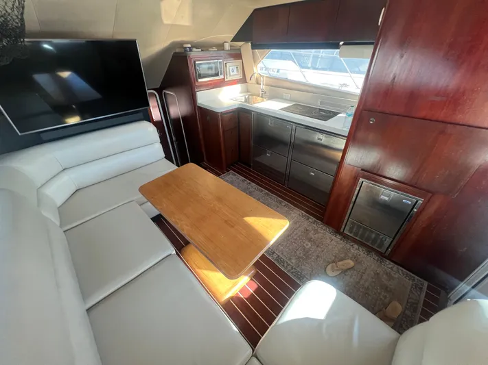 Uno Mas Yacht Photos Pics Luxurious interior of 2001 Luhrs 360 Convertible yacht with modern kitchen and seating area.