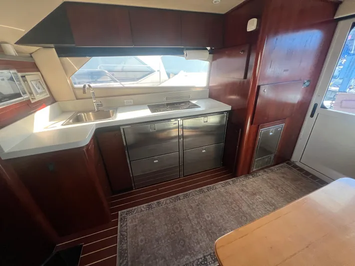Uno Mas Yacht Photos Pics 2001 Luhrs 360 Convertible yacht kitchen with modern appliances and wooden cabinetry.