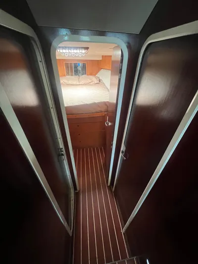Uno Mas Yacht Photos Pics Interior view of 2001 Luhrs 360 Convertible yacht cabin with wooden flooring and cozy bed.