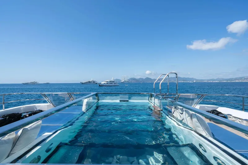  Yacht Photos Pics Luxurious Sanlorenzo 52Steel yacht with pool, 2018 model, cruising on a clear blue sea.