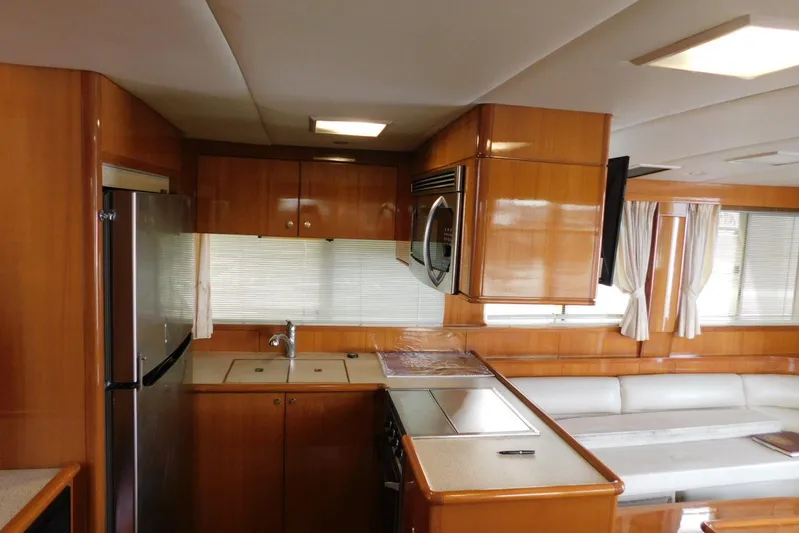 Liquid Gold Yacht Photos Pics Luxurious kitchen interior of 2001 Jefferson Pilothouse 57 yacht with wood cabinetry and modern appliances.