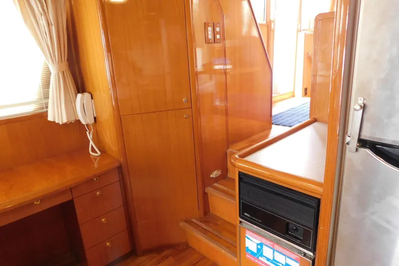 Liquid Gold Yacht Photos Pics Interior of 2001 Jefferson Pilothouse 57 yacht with wooden cabinetry and staircase.