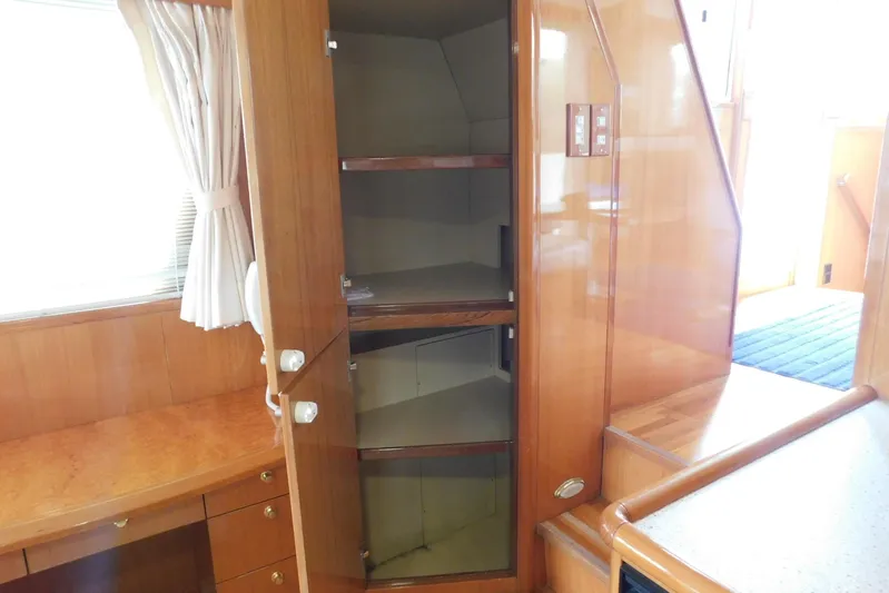Liquid Gold Yacht Photos Pics Interior of 2001 Jefferson Pilothouse 57 yacht with open wooden cabinet and desk.