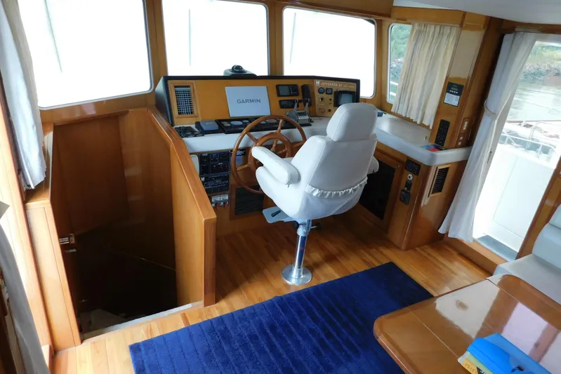 Liquid Gold Yacht Photos Pics Pilothouse interior of 2001 Jefferson Pilothouse 57 yacht with navigation equipment and captain's chair.