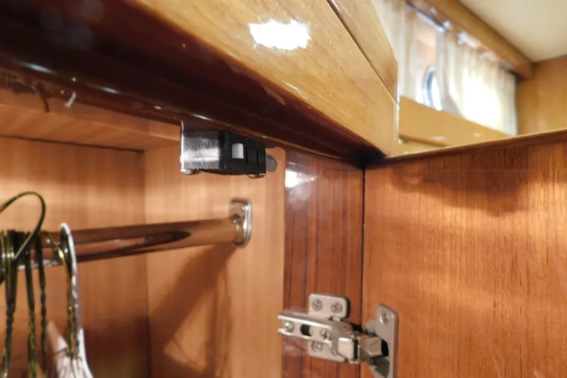 Liquid Gold Yacht Photos Pics Wooden cabinet interior on a 2001 Jefferson Pilothouse 57 yacht, featuring a metal rod and hinge.