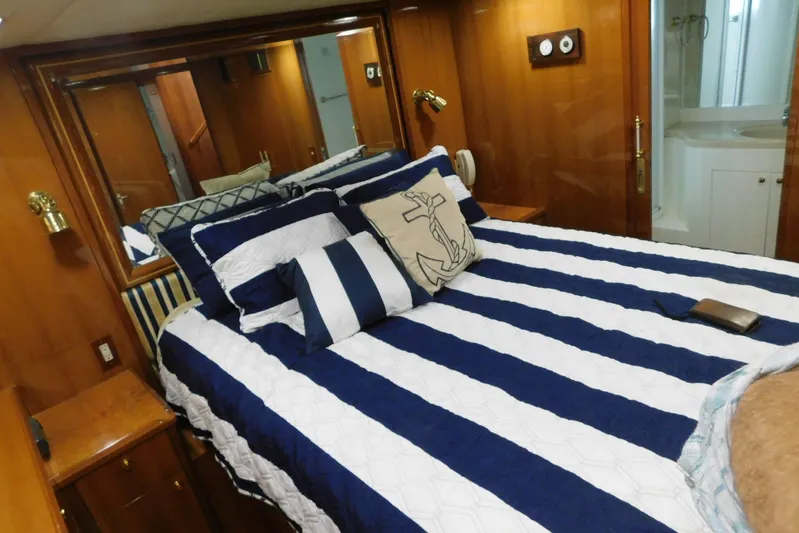 Liquid Gold Yacht Photos Pics Luxurious bedroom in 2001 Jefferson Pilothouse 57 yacht with nautical-themed decor.