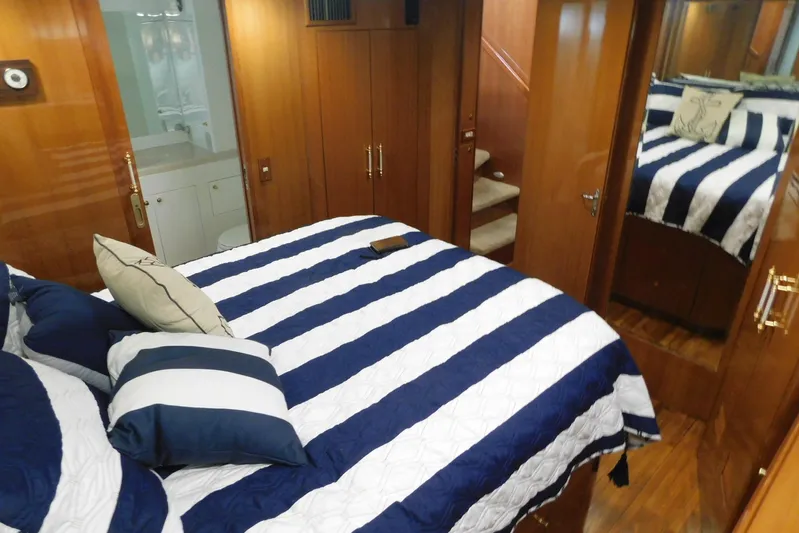Liquid Gold Yacht Photos Pics Luxurious bedroom interior of 2001 Jefferson Pilothouse 57 yacht with striped bedding.
