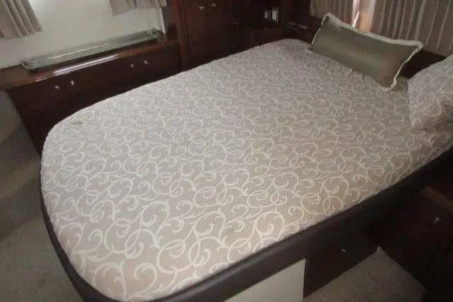  Yacht Photos Pics 2008 Carver 47 Motor Yacht bedroom with patterned bedspread and wooden cabinetry.