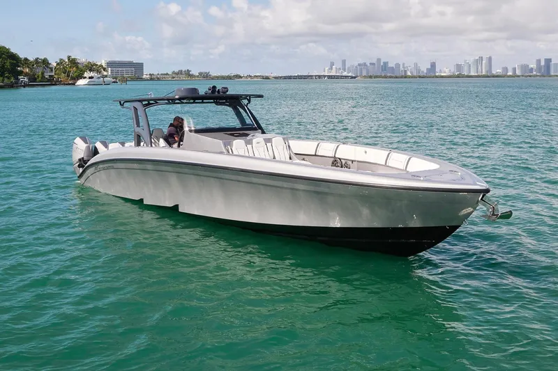 Devenzo Yacht Photos Pics 2022 Midnight Express 43 Open boat on turquoise water with city skyline in background.