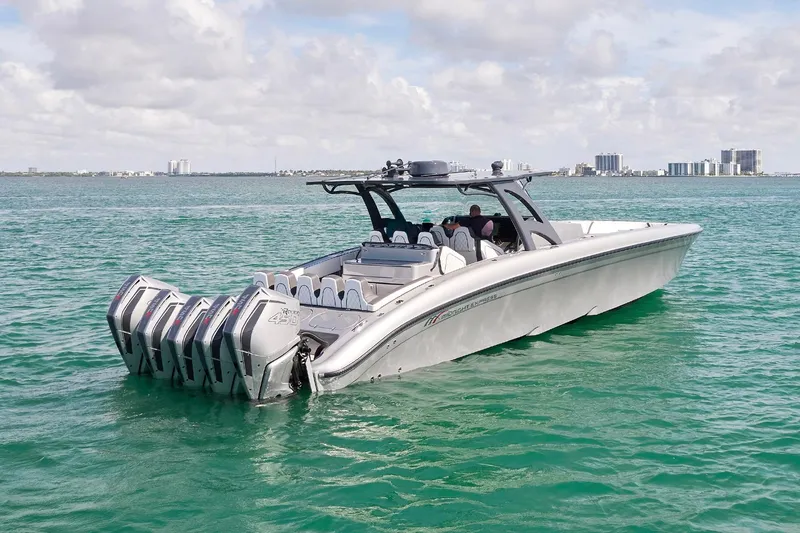 Devenzo Yacht Photos Pics 2022 Midnight Express 43 Open boat cruising on turquoise water under a cloudy sky.