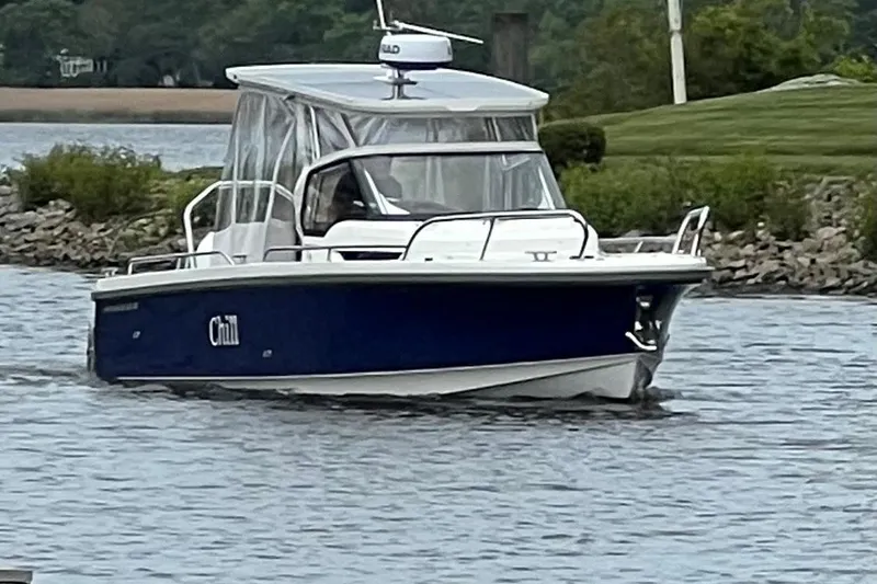  Yacht Photos Pics 2025 Nimbus Tender 8 boat cruising on a calm river with lush greenery.