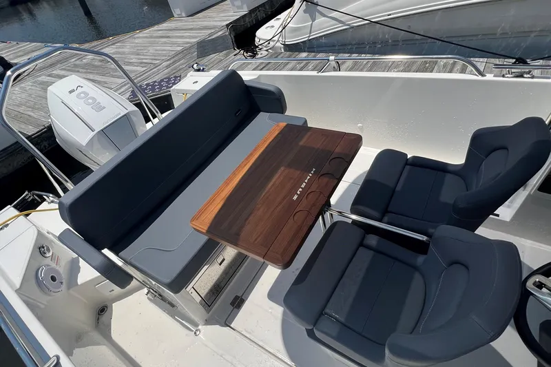  Yacht Photos Pics Luxurious seating area on 2025 Nimbus Tender 8 boat with wooden table and modern chairs.