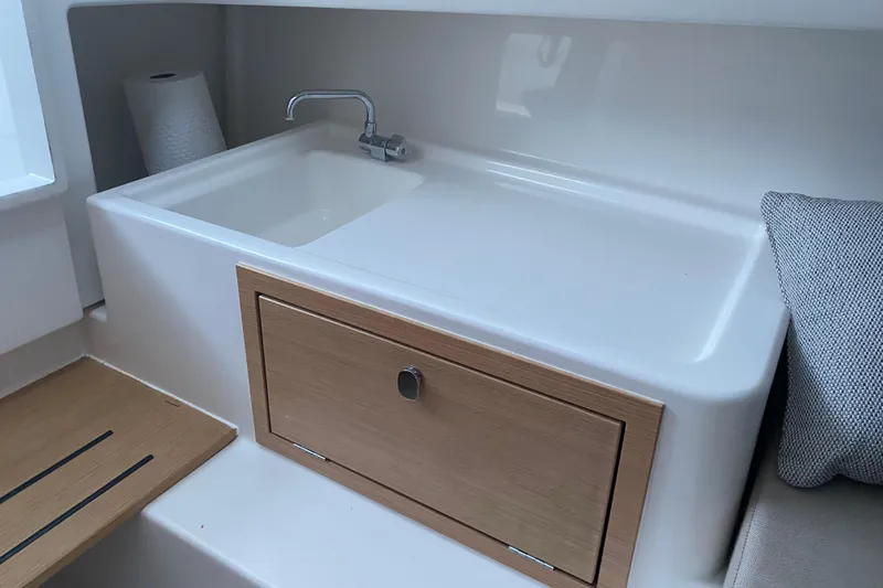  Yacht Photos Pics Modern sink area in 2025 Nimbus Tender 8 boat, featuring sleek design and wooden cabinetry.