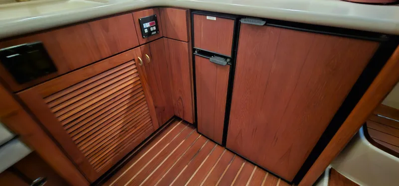 Sunbeam Yacht Photos Pics 2002 Pursuit 3800 Express yacht interior with wooden cabinetry and flooring.