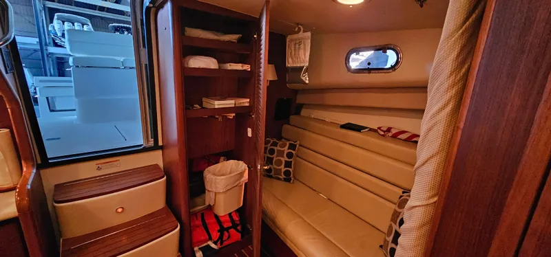 Sunbeam Yacht Photos Pics 2002 Pursuit 3800 Express cabin interior with seating, storage, and porthole window.
