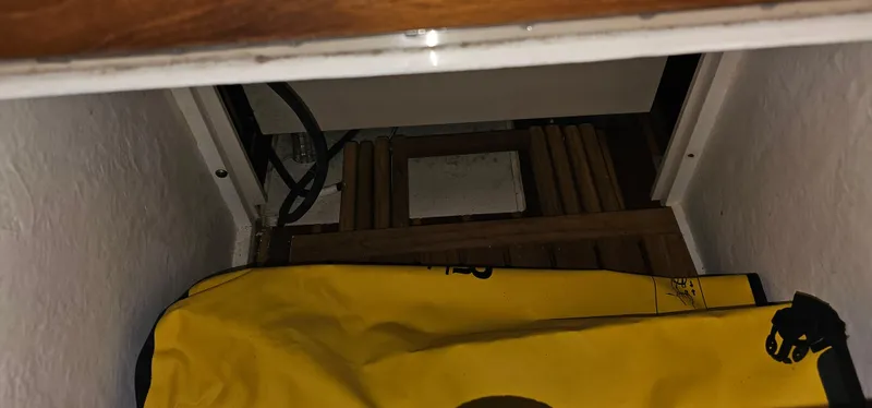 Sunbeam Yacht Photos Pics Storage compartment in a 2002 Pursuit 3800 Express boat with yellow bag and wooden slats.
