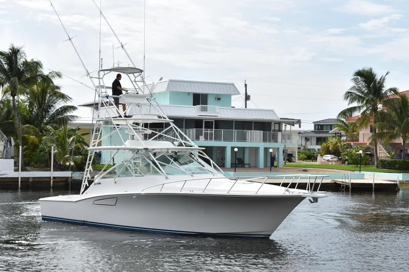 Kraken Yacht Photos Pics 2007 Cabo Express boat cruising near waterfront homes with palm trees.