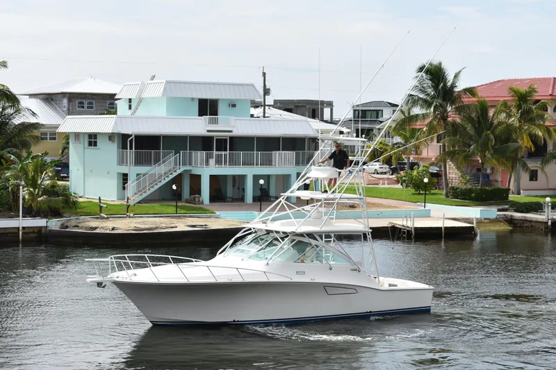 Kraken Yacht Photos Pics 2007 Cabo Express yacht cruising near waterfront homes with palm trees.