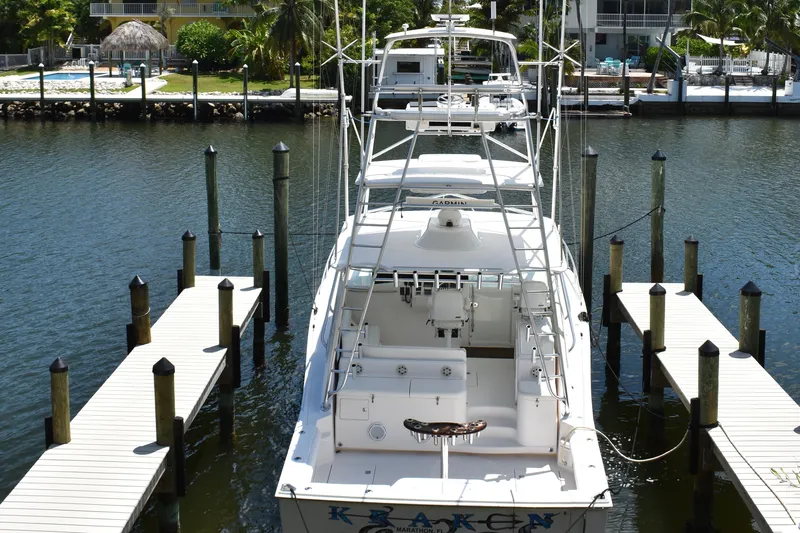 Kraken Yacht Photos Pics 2007 Cabo Express boat docked at marina, surrounded by calm water and lush greenery.