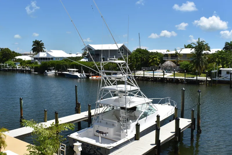 Kraken Yacht Photos Pics 2007 Cabo Express boat docked in a scenic marina with waterfront homes.