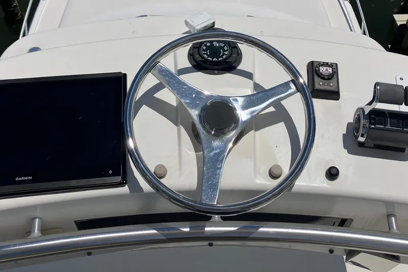 Kraken Yacht Photos Pics Steering wheel and controls of a 2007 Cabo Express boat cockpit.