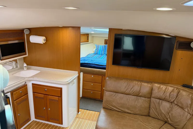 Kraken Yacht Photos Pics Interior of a 2007 Cabo Express yacht with kitchen, TV, and seating area.