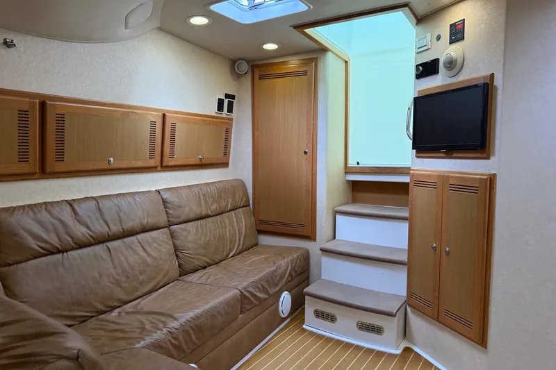 Kraken Yacht Photos Pics 2007 Cabo Express interior with leather seating, wooden cabinets, and a small TV.