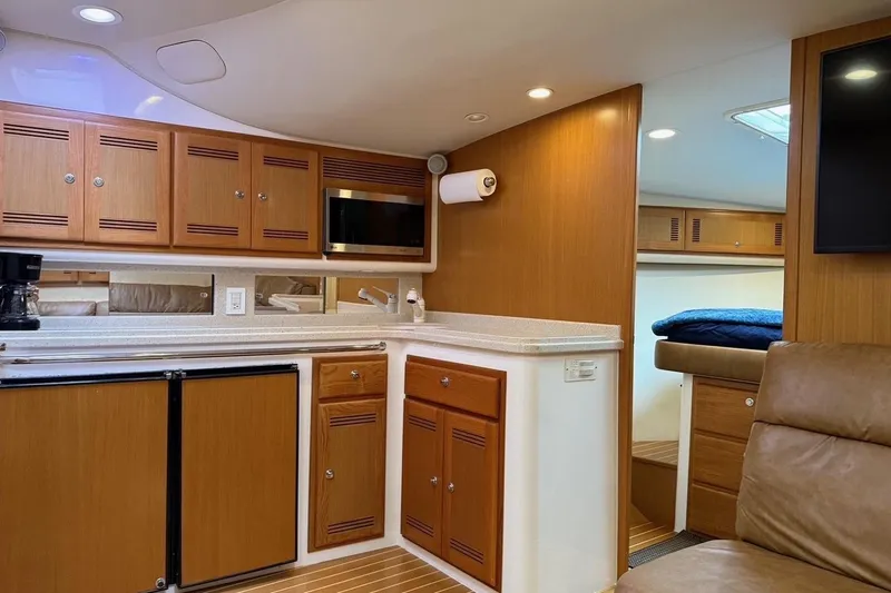 Kraken Yacht Photos Pics 2007 Cabo Express yacht interior with kitchenette, wood cabinets, and cozy seating area.