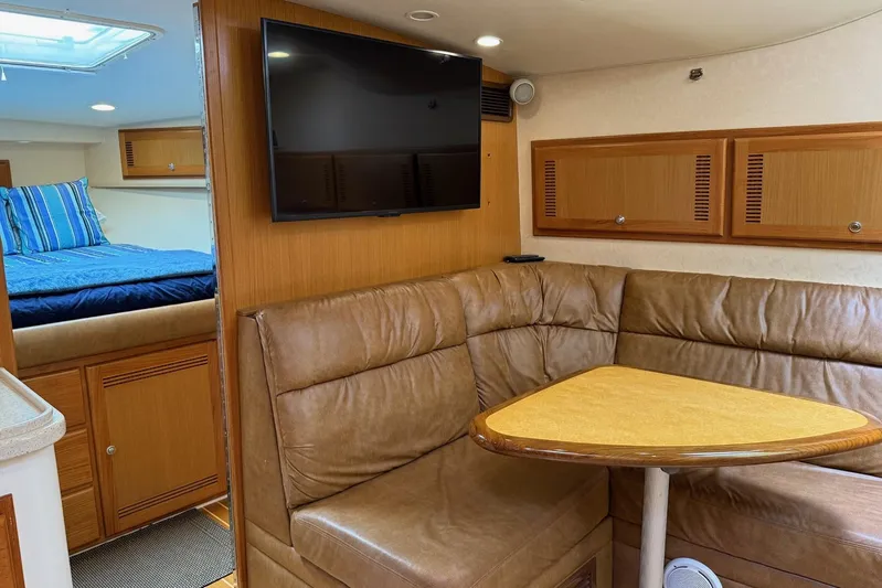 Kraken Yacht Photos Pics 2007 Cabo Express yacht interior with leather seating, TV, and cozy sleeping area.