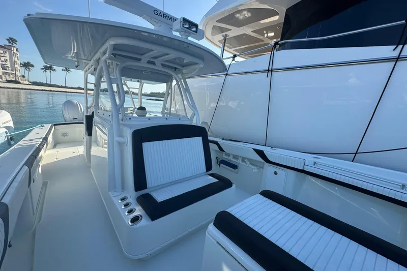  Yacht Photos Pics 2014 Yellowfin 39 Offshore boat interior with seating and Garmin equipment, docked by water.
