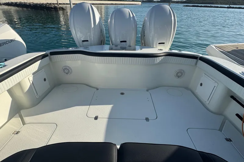  Yacht Photos Pics 2014 Yellowfin 39 Offshore boat deck with triple outboard engines, docked on calm water.
