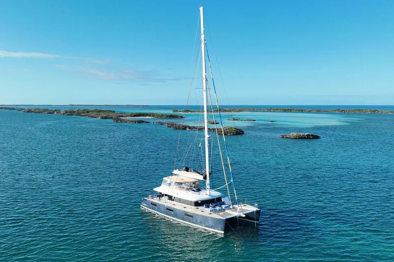 Andromeda Yacht Photos Pics 2016 Lagoon 620 catamaran sailing in clear blue waters with distant islands.
