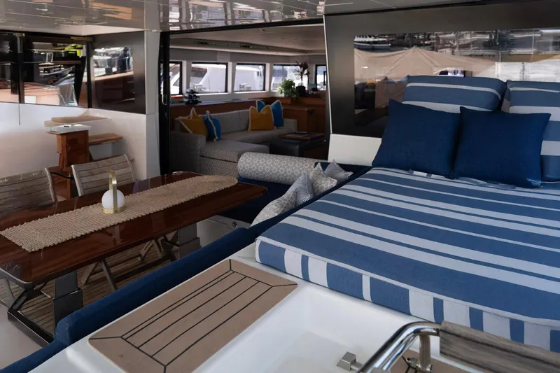 Andromeda Yacht Photos Pics Luxurious interior of 2016 Lagoon 620 yacht with striped bedding and elegant dining area.